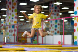 Little Excited Girl Photographed At The Jump On The Trampoline